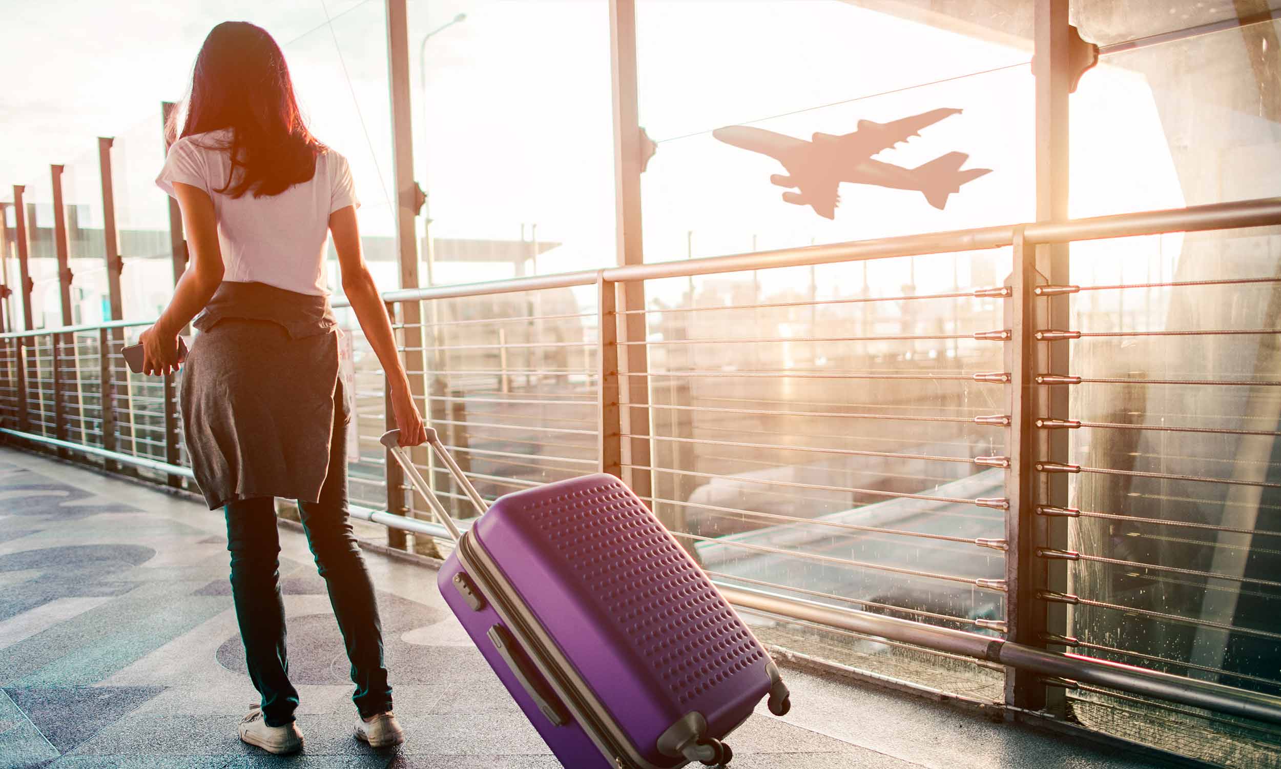 Frau mit Koffer am Flughafen